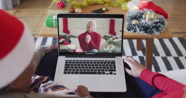 アフリカ系アメリカ人の母親と娘がノートパソコンを使ってクリスマスのビデオ通話をしている クリスマスやお祭りや通信技術は — ストック動画