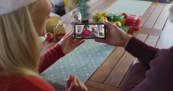 Casal Caucasiano Com Chapéus Papai Noel Usando Smartphone Para Chamada — Vídeo de Stock