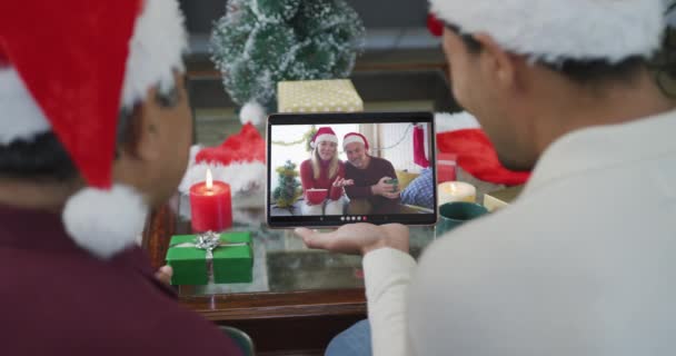 Бирациарный Отец Сын Шляпах Санты Используют Планшет Рождественского Видео Звонка — стоковое видео