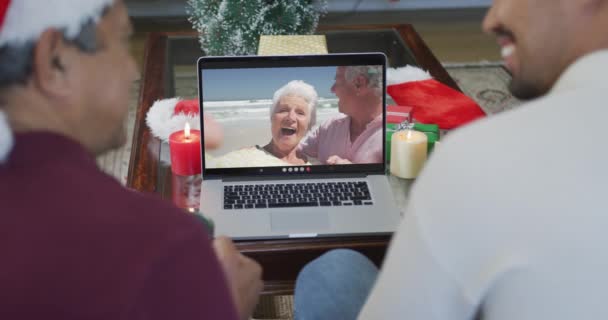 Dwurasowy Ojciec Syn Kapeluszach Mikołaja Pomocą Laptopa Boże Narodzenie Rozmowy — Wideo stockowe