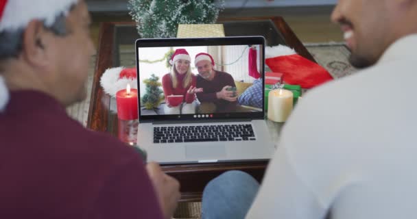 孩子的父亲和儿子戴着桑塔帽子 他们用笔记本电脑在屏幕上播放圣诞视频 圣诞节 节日和通信技术 — 图库视频影像