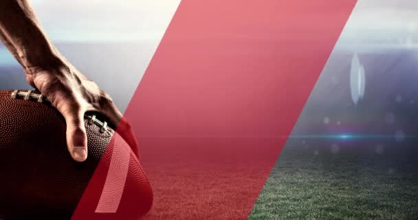 アメリカサッカーを保持する男性の手の上に移動する斜めの赤いストライプのアニメーション 草のピッチ上 スポーツ アメリカンフットボールのコンセプトをデジタルで生成し — ストック動画