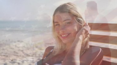 Amerika Birleşik Devletleri bayrağının sahildeki mutlu beyaz kadın üzerinde canlandırılması. Amerikan tarihi, vatanseverlik ve bağımsızlık kavramı dijital olarak oluşturulmuş video.