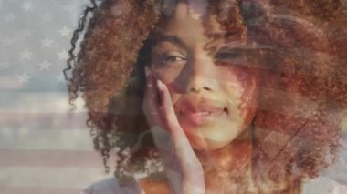 Sahildeki Afrikalı Amerikalı bir kadın yüzünden Amerika Birleşik Devletleri bayrağının animasyonu. Amerikan tarihi, vatanseverlik ve bağımsızlık kavramı dijital olarak oluşturulmuş video.