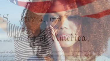 Sahildeki mutlu Afro-Amerikan kadını yerine Amerika Birleşik Devletleri bayrağının animasyonu. Amerikan tarihi, vatanseverlik ve bağımsızlık kavramı dijital olarak oluşturulmuş video.