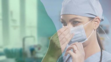 Kadın doktorun yüz maskesi takması üzerine İrlanda bayrağı animasyonu. Koronavirüs salgını sırasında dijital olarak üretilen video sırasında sağlık ve koruma.