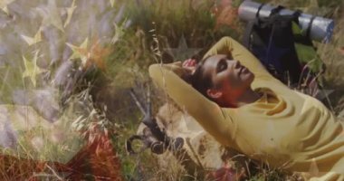 Amerika Birleşik Devletleri bayrağının doğada dinlenen kadın üzerine canlandırılması. Amerikan tarihi, vatanseverlik ve bağımsızlık kavramı dijital olarak oluşturulmuş video.