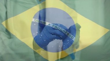 Cerrahi eldiven takan doktorun elleri üzerinde Brezilya bayrağı animasyonu. Koronavirüs salgını sırasında dijital olarak üretilen video sırasında sağlık ve koruma.