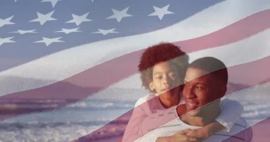 Amerika Birleşik Devletleri bayrağının Afrika kökenli Amerikalı baba ve oğul üzerinde sahile çekilmesi. Amerikan tarihi, vatanseverlik ve bağımsızlık kavramı dijital olarak oluşturulmuş video.