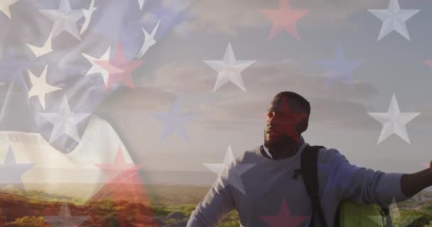 アフリカ系アメリカ人が山の中をハイキングする際のアメリカ国旗のアニメーション 愛国心とお祝いのコンセプトをデジタルで — ストック動画