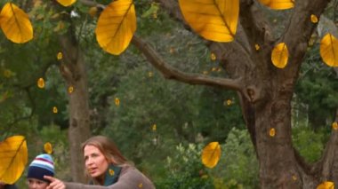 Parktaki mutlu beyaz ailenin üzerine düşen sonbahar yapraklarının animasyonu. sonbahar, sonbahar ve mevsimler dijital olarak üretilen video konsepti.