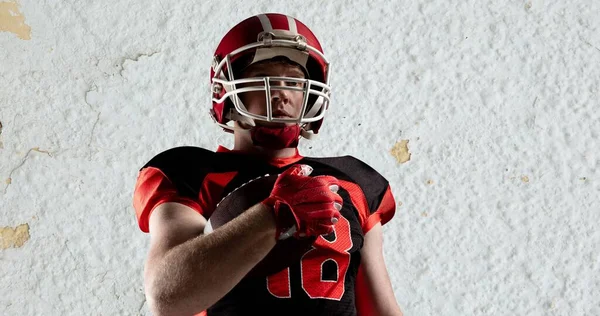 Male American Footballer Wearing Helmet Uniform Holding Ball White Textured — Stock Photo, Image