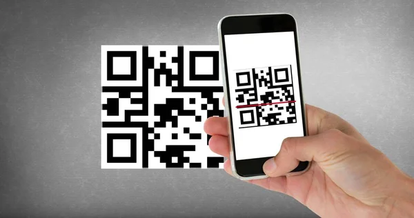 Cropped hand scanning qr code with smart phone with copy space on gray background. wireless technology, mobile application and cashless technology concept.