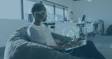 Ofisteki dizüstü bilgisayarını kullanan Afro-Amerikan kadının sosyal medya ikonlarının animasyonu. iş, küresel iletişim ve dijital arayüz teknolojisi konsepti dijital olarak oluşturulmuş video.