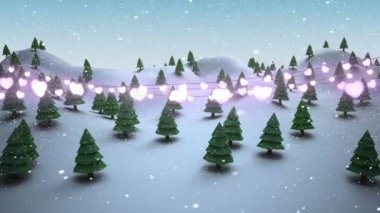 Kış manzarasına düşen kara karşı parıldayan kalp şeklindeki peri ışıkları süslemesi. Noel şenliği ve kutlama konsepti