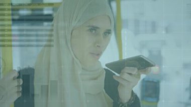 Akıllı telefon kullanan tesettürlü kadının istatistik ve veri işleme animasyonu. küresel bağlantılar, teknoloji, veri işleme ve dijital arayüz konsepti dijital olarak oluşturulmuş video.