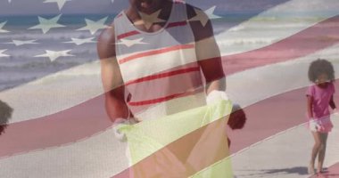 Amerika Birleşik Devletleri bayrağının animasyonu mutlu Afrika kökenli Amerikalı baba ve oğul plajda. Amerikan tarihi, vatanseverlik ve bağımsızlık kavramı dijital olarak oluşturulmuş video.