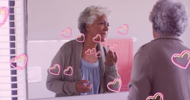 Animacja Różowych Serc Nad Szczęśliwą Białą Starszą Kobietą Nakładającą Szminkę — Wideo stockowe