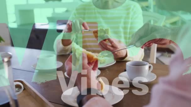 家庭で朝食を取っている幸せな白人のシニアカップルの上に赤と白のビブのテキストのアニメーション 退職者のライフスタイル 友情と幸福の概念デジタルで生成されたビデオ — ストック動画