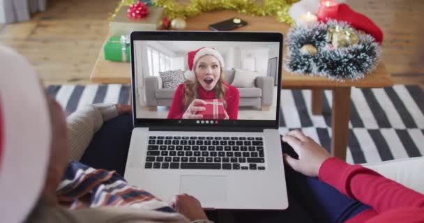 アフリカ系アメリカ人の母親と娘がクリスマスのビデオ通話にラップトップを使用している クリスマスやお祭りや通信技術は — ストック動画