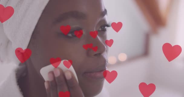 Kırmızı Kalpler Animasyonu Mutlu Afro Amerikan Kadınlarının Evde Yüzünü Temizlemesi — Stok video