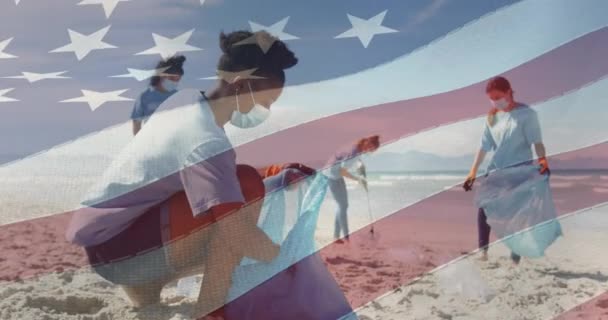 顔のマスクのクリーニングビーチで人々にアメリカの国旗のアニメーション アメリカの歴史愛国心と独立の概念をデジタルで生成したビデオ — ストック動画