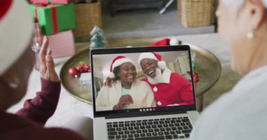 Farklı üst düzey bayan arkadaşlar, mutlu çiftle birlikte ekranda Noel görüntülü konuşma yapmak için dizüstü bilgisayar kullanıyorlar. Noel, şenlik ve iletişim teknolojisi.