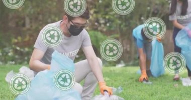 Parkta geri dönüşüm torbaları olan çocuklar üzerindeki yeşil geri dönüşüm işaretlerinin canlandırılması. ekoloji, yeşil yaşam ve sürdürülebilirlik kavramı dijital olarak oluşturulmuş video.