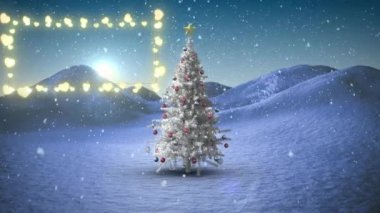Kış manzarasında Noel ağacının üzerine düşen kar tanelerine karşı dekoratif parlak ışıklar. Noel şenliği ve kutlama konsepti