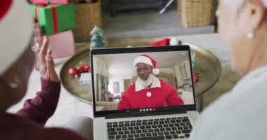 Farklı son sınıf kız arkadaşları Noel 'de ekranda mutlu noel baba videosu için dizüstü bilgisayar kullanıyor. Noel, şenlik ve iletişim teknolojisi.