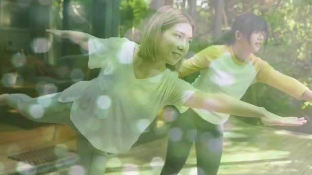 庭で運動するアジアの母親と娘の上に輝くスポットのアニメーション レジャー アクティブライフスタイル 屋外活動のコンセプトデジタル生成ビデオ — ストック動画