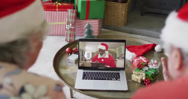 クリスマスのビデオ通話にラップトップを使用しているシニア白人カップルは 画面上の幸せなサンタと クリスマスやお祭りや通信技術は — ストック動画
