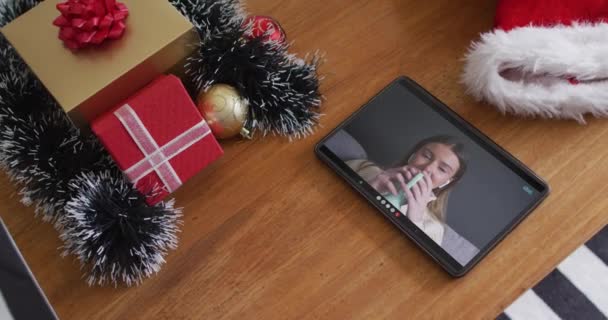 笑顔の白人女性がタブレットでクリスマスビデオ通話でコーヒーを飲んでいます クリスマスやお祭りや通信技術は — ストック動画