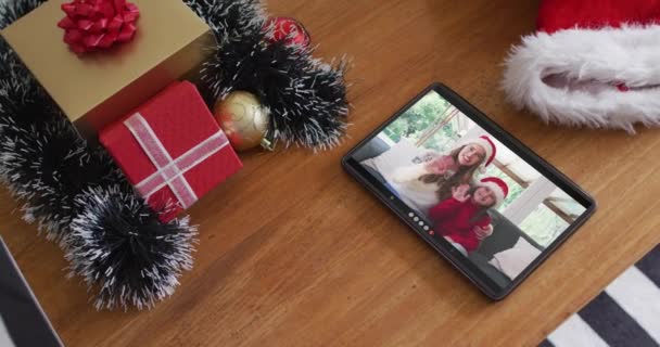 在平板电脑上播放圣诞视频时 笑着带着圣诞帽的高加索母亲和女儿 圣诞节 节日和通信技术 — 图库视频影像