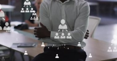 Afro-Amerikan iş adamının ofisindeki bağlantı simgelerinin canlandırılması. küresel iş, dijital arayüz ve teknoloji konsepti dijital olarak oluşturulmuş video.