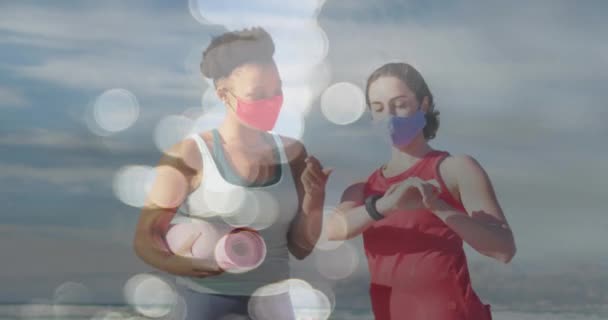 ビーチでヨガマットやフェイスマスクを持つ多様な女性の友人以上のスポットのアニメーション 感染症の概念がデジタルで生成されたビデオで — ストック動画