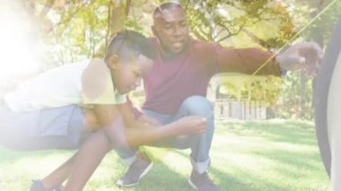 Afro-Amerikan baba ve oğlunun yaprakların üzerinde çadır kurduğu animasyon. eğlence, birliktelik ve refah konsepti dijital olarak oluşturulmuş video.