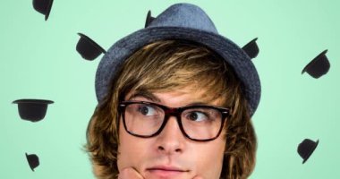 Yeşil arka planda düşen şapkaların üzerine şapka ve gözlük takan beyaz adam animasyonu. moda tasarımı ve giyim konsepti dijital olarak oluşturulmuş video.