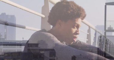 Afro-Amerikan bir adamın şehir manzarası üzerinde koştuktan sonra dinlenmesi. eğlence, spor ve aktif yaşam tarzı konsepti dijital olarak oluşturulmuş video.