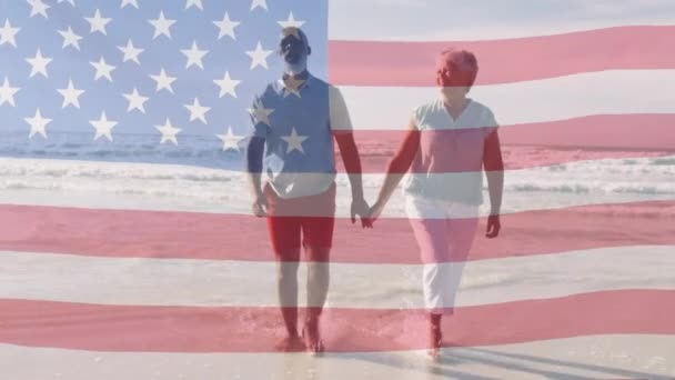 Animacja Szczęśliwej Afrykańskiej Pary Seniorów Spacerujących Plaży Nad Amerykańską Flagą — Wideo stockowe