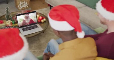 Noel Baba şapkalı bir sürü aile Noel Baba 'nın ekranında mutlu bir Noel Baba ile yaptığı görüntülü konuşma için laptop kullanıyor. Noel, şenlik ve iletişim teknolojisi.