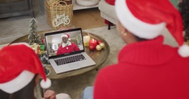 Noel Baba şapkalı bir sürü aile Noel Baba 'nın ekranında mutlu bir Noel Baba ile yaptığı görüntülü konuşma için laptop kullanıyor. Noel, şenlik ve iletişim teknolojisi.