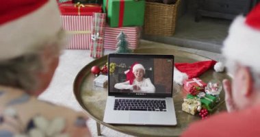 Üst düzey Kafkasyalı çift ekranda mutlu bir kadınla yılbaşı görüntüsü için dizüstü bilgisayar kullanıyor. Noel, şenlik ve iletişim teknolojisi.