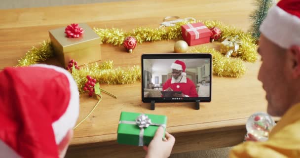 白人父亲和儿子与桑塔帽子使用石碑圣诞节视频通话与桑塔在屏幕上 圣诞节 节日和通信技术 — 图库视频影像