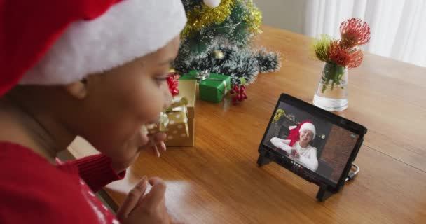 戴桑塔帽的非裔美国女人用平板电脑和屏幕上的女人打圣诞视频电话 圣诞节 节日和通信技术 — 图库视频影像