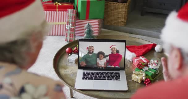 画面上の幸せな家族とクリスマスのビデオ通話のためのラップトップを使用してシニア白人カップル クリスマスやお祭りや通信技術は — ストック動画