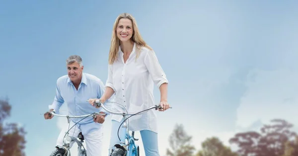 Imagem Composta Casal Sênior Caucasiano Andando Bicicleta Contra Céu Azul — Fotografia de Stock