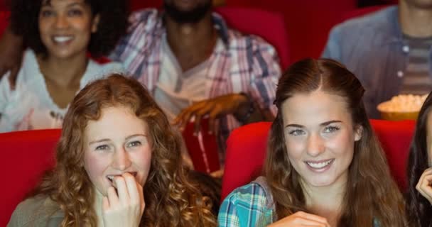 Animace šťastné rozmanité skupiny lidí, kteří jedí popcorn v kinech. národní popcorn den a koncepce oslav digitálně generované video.
