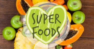 Super foods text banner against various fruits on wooden surface. vegan, organic and healthy food concept