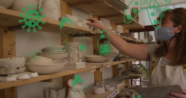 Animatie Van Viruspictogrammen Boven Blanke Vrouw Met Gezichtsmasker Inspecteren Aardewerk — Stockvideo